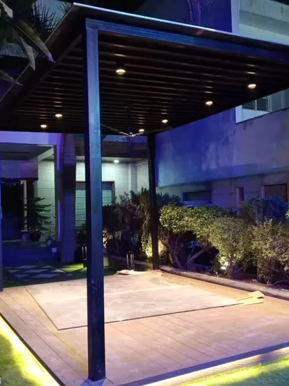 The Dwarka front yard pergola at night. The structure is equipped with spotlights and the deck is lined with LED strips, creating a stunning focal point.