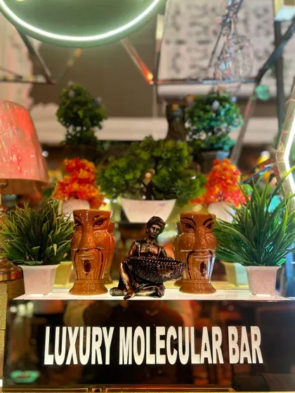A detailed view of the decor on our tiki bar, featuring miniature plants, unique statues, and our branded bar front.