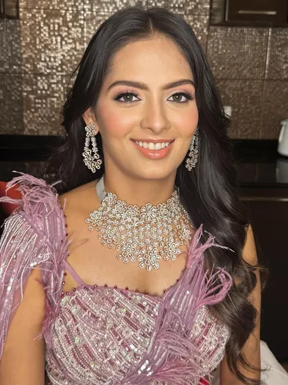 A smiling portrait that captures the joy of the occasion, with makeup that enhances her natural beauty.