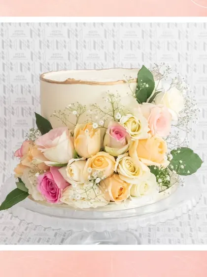 A beautiful floral wedding cake featuring a cascade of fresh roses in pastel shades, perfect for a romantic garden wedding.