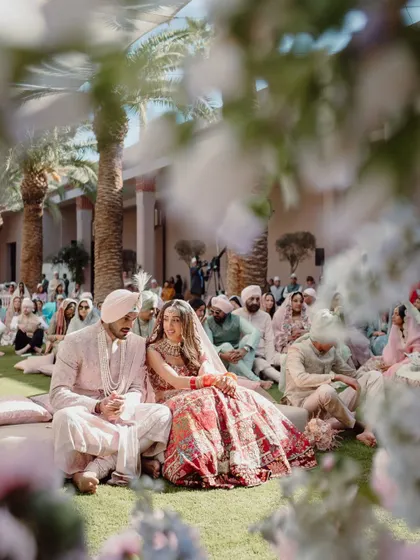 A serene moment from an Anand Karaj ceremony at the Four Seasons, Marrakech. The garden setting, with guests seated on the grass, created an intimate and peaceful atmosphere for the Sikh wedding.