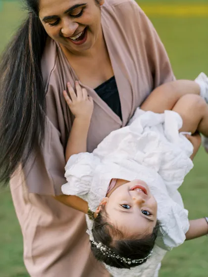 A mother swinging her daughter around, both laughing. The movement and joy make this a dynamic and happy photo.