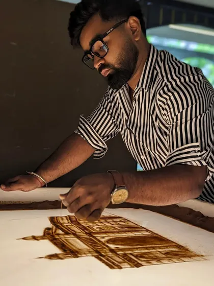 A shot of me working on the Lodha Group sand art, carefully adding details to the architecture.
