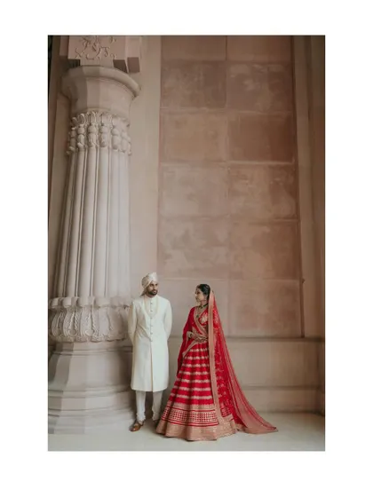 A timeless portrait that feels both regal and romantic. The grand pillars of the venue provide a majestic backdrop for the elegantly dressed bride and groom.