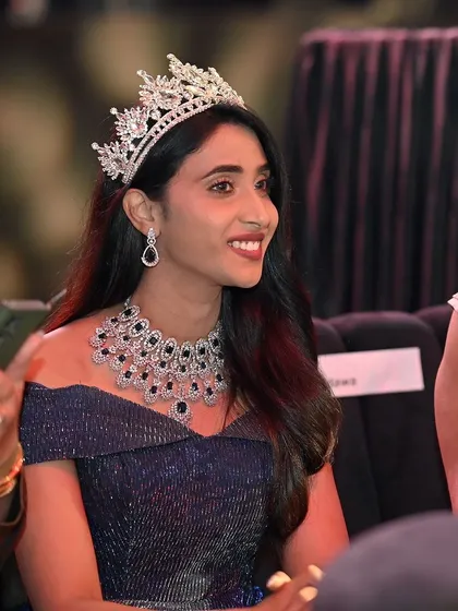 A close-up of a smiling beauty queen, radiant in her crown and jewels. This highlights the beauty and elegance central to pageantry.