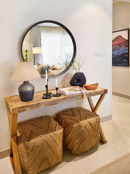 An entryway should be both stylish and functional. Here, I used a slim console table for keys and mail, with jute pouffes tucked underneath for seating. The large round mirror makes the space feel bigger and is perfect for a last look before heading out.