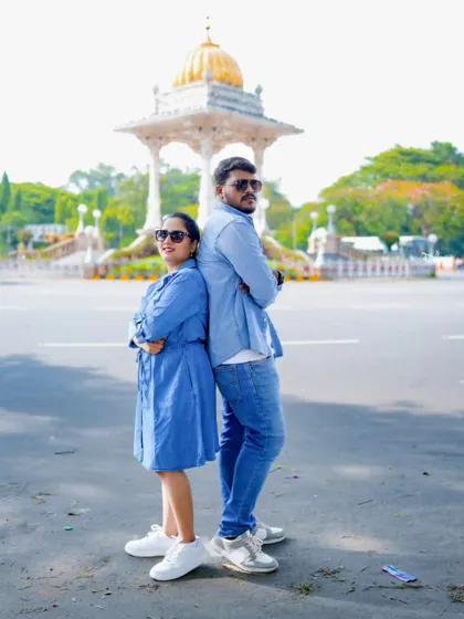 A fun back-to-back pose in front of a monument in Mysore. This shows the playful side of the couple's relationship.