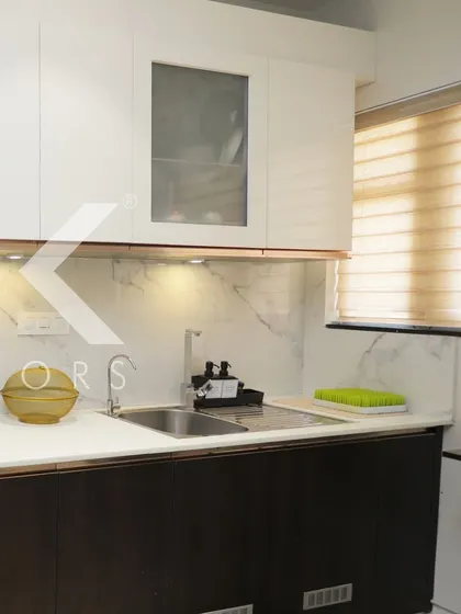 A close-up of a white kitchen with dark brown lower cabinets, showing the clean lines and practical layout designed to meet our client's needs.