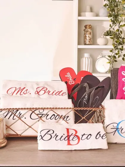 This hamper is designed for both the bride and groom. It includes personalized "Mr. Groom" and "Ms. Bride" towels, matching flip-flops, and other goodies for the couple to enjoy together.