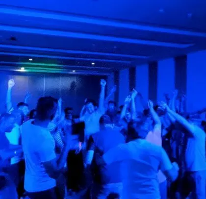 A wide shot of the dance floor under cool blue lighting.