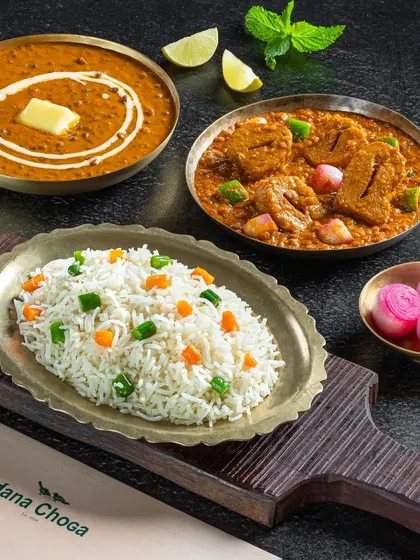 A meal combo from Dana Choga featuring Dal Makhani, Soya Chaap Masala, and vegetable rice.
