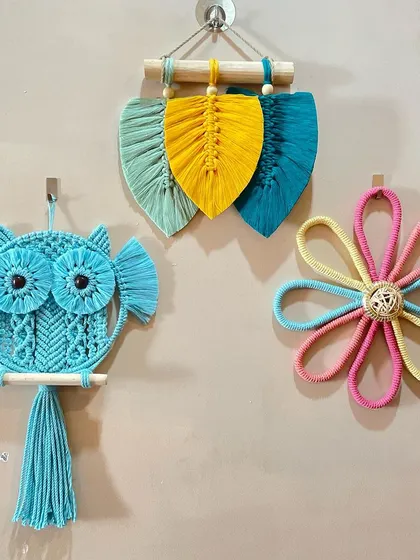A colorful collection of my nature-inspired wall decor. Here you can see a blue owl, a multi-colored flower, and a trio of leaves hanging together.