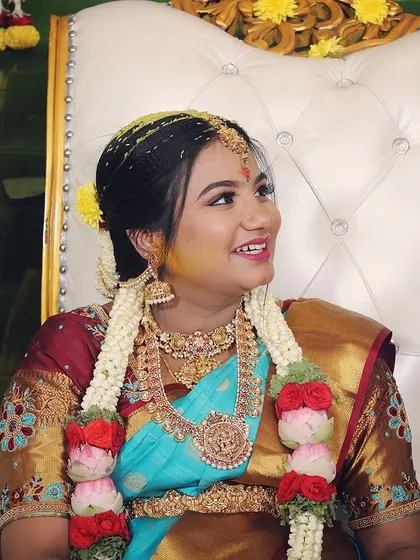 A candid shot of a client at her baby shower, wearing a traditional temple jewellery set.