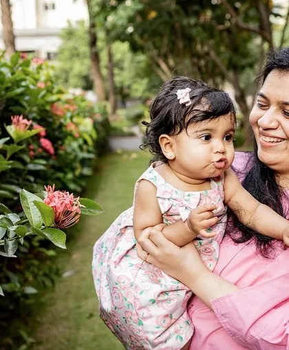 A candid moment between a mother and her baby girl outdoors. The black and white tones draw attention to their sweet expressions.
