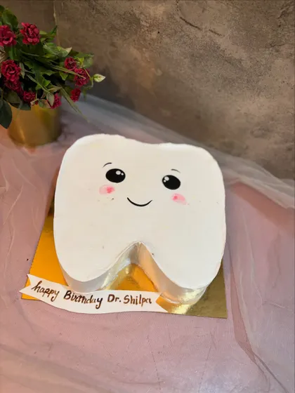A cute, blushing tooth cake for Dr. Shilpa's birthday. It's a sweet way to celebrate someone in the dental profession.