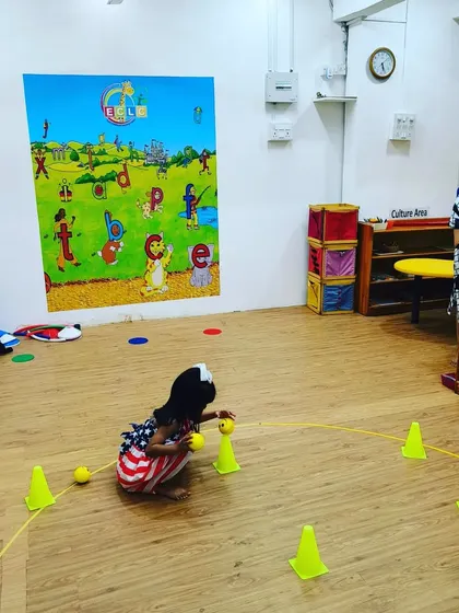 This little one is carefully collecting balls during a game. This action of squatting and standing up is a great functional movement that strengthens leg muscles and improves balance.