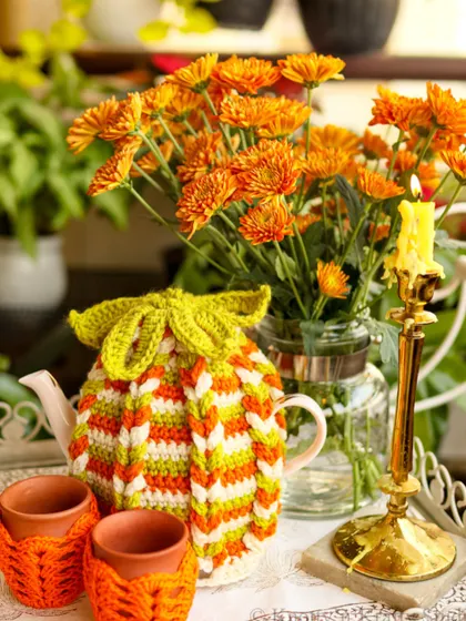 Even bold autumn colours can feel fresh for summer. Here, my striped tea cozy and kulhad covers are styled with lots of greenery for a refreshing vibe.