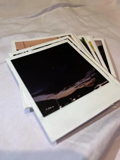 A stack of thick Polaroids, with a moody night sky photo on top. This highlights the rich, deep colors my printing process can achieve, even for low-light images.