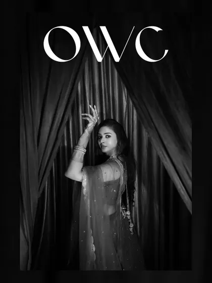 A dramatic black and white portrait of the bride, her pose graceful and artistic.