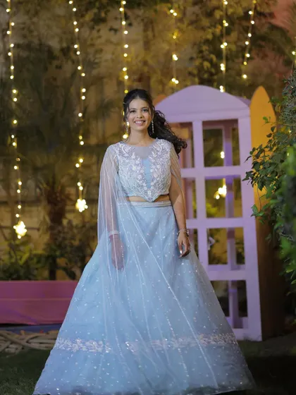 A full length view of this dreamy sangeet outfit. The soft colors and flowing silhouette are complemented by a romantic hairstyle and makeup.