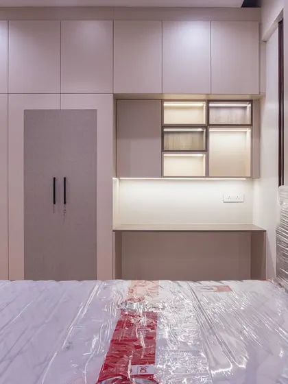 A closer look at the integrated wardrobe and study unit in the guest bedroom. The backlit open shelves provide a space for display, adding a personal touch.