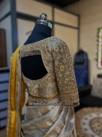 The back view of the blouse for the off-white and yellow saree, featuring a stylish square cutout.