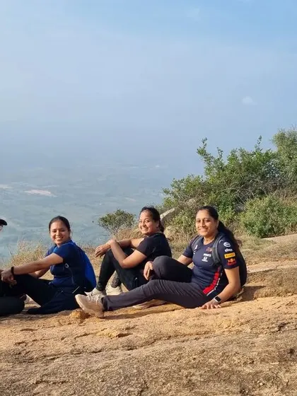 A group of women resting on a rock, enjoying the panoramic view from the summit.