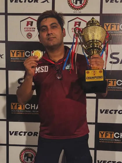 Another one for the cabinet. Our director proudly displays the championship trophy and his winner's medal after a successful campaign.