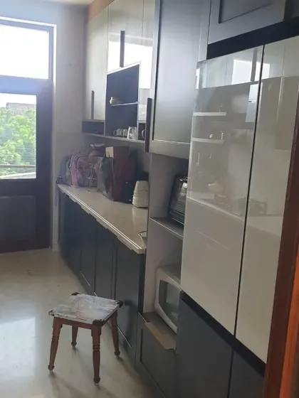 A long shot of a galley-style kitchen with dark grey cabinets and white accents. This project showcases our ability to design for different layouts while maintaining a luxury feel.