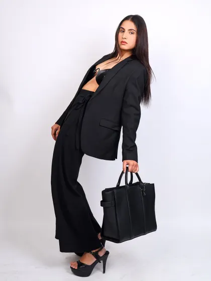 A full-length shot for Yuvastree, showcasing a stylish black handbag. The dynamic pose and clean white background make this ideal for e-commerce and catalog use.