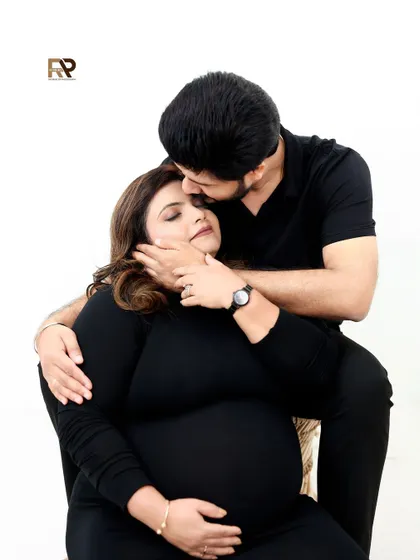 A tender moment of affection. The dad-to-be gently kisses his partner's forehead, a classic expression of love and care captured in a modern, minimalist style.