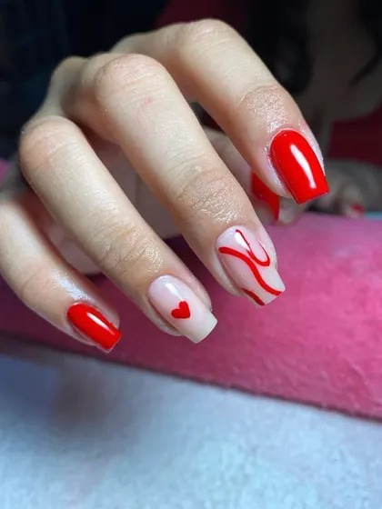 A cute and simple design featuring bright red nails with accent art, including a minimalist heart and abstract swirls.