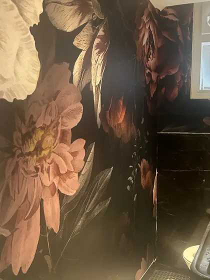 This moody, large-scale floral wallpaper is going up in a powder room. It's going to be a dramatic and beautiful statement.