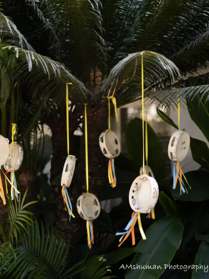Hand-painted tambourines with colorful ribbons hang from a tree, waiting for little hands to come and "move to the groove."