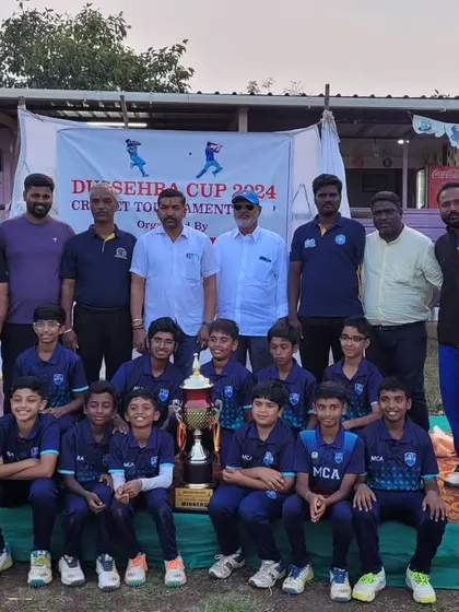 The team and coaching staff posing with the Dasara Cup Hubli trophy after being crowned Emerging Champions.