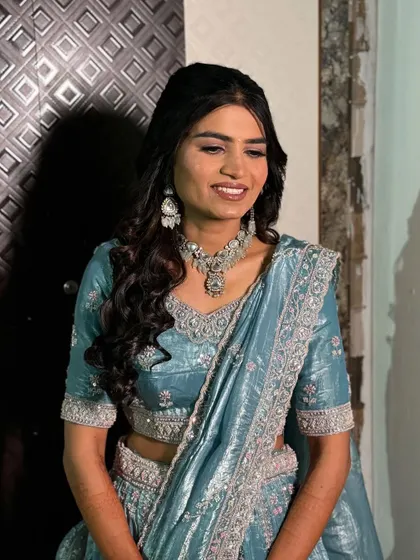 The bride's smile lights up her whole face. The makeup is designed to look fresh and natural, enhancing her joyful expression.