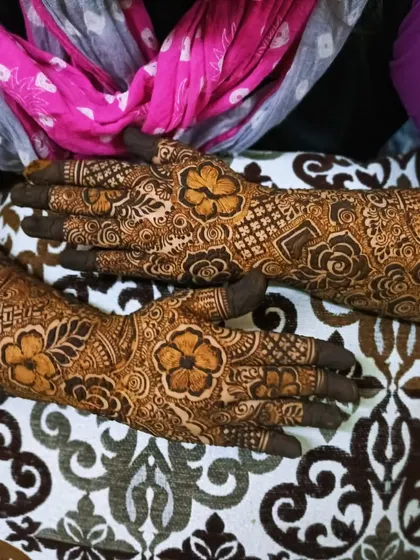 A candid shot of a bridal mehndi, showing the intricate details on the back of the hands.