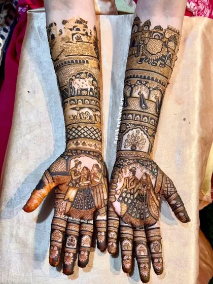 A beautiful bridal mehandi design telling a story. It features a family portrait on one hand and a couple's portrait on the other, surrounded by elephants and traditional patterns.
