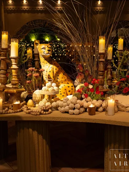 A detail from our 'Mid-Century Mod' themed night. This corner features a cheetah sculpture, dried grasses, and warm candlelight, blending organic forms with vintage ornamentation for a playful yet timeless feel.