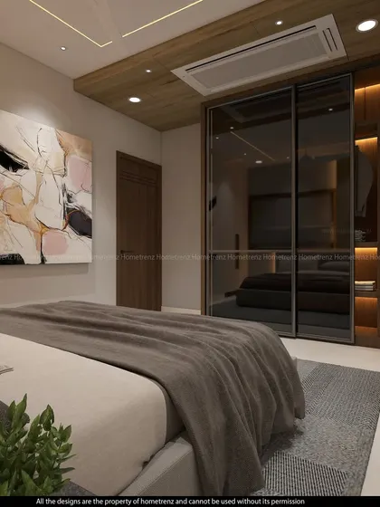 A guest bedroom with a wardrobe featuring smoked glass sliding doors and warm interior lighting.