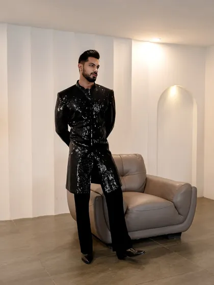 This standing pose shows the sharp, tailored fit of the sequined jacket. It's a piece that commands attention and exudes a sense of modern luxury.