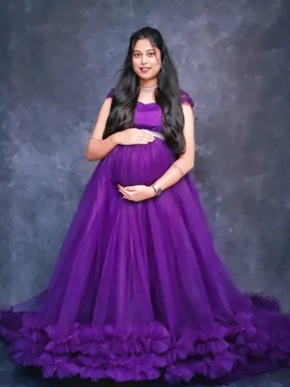 A classic maternity pose in our full-skirted purple gown. The ruffled hem adds a beautiful finishing touch to the dress.