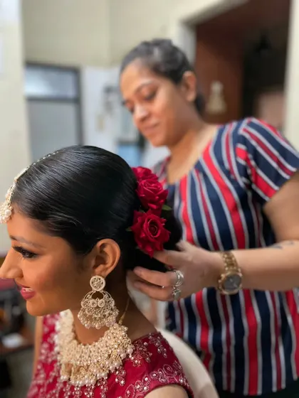 A behind the scenes moment of me placing fresh roses into this bride's intricate bun. Adding fresh flowers is one of my favorite ways to personalize a traditional bridal hairstyle.