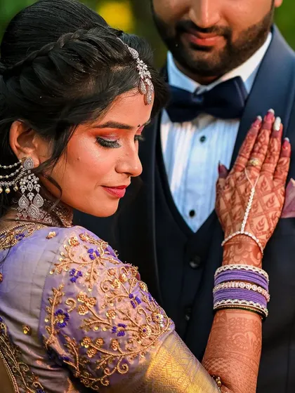 A close-up portrait of the bride, showcasing her intricate jewelry, henna, and the beautiful embroidery on her blouse.
