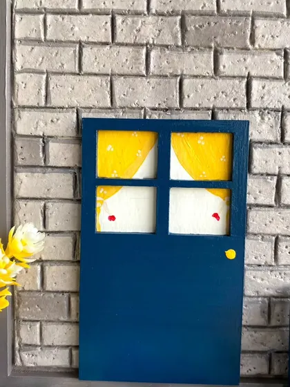 The miniature door and window with hand-painted curtains give a peek into the cozy home I imagined for this family nameplate.