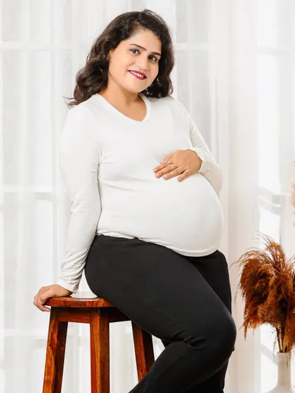 A simple and beautiful solo portrait in a comfortable white top and black pants. This shows that you don't always need a gown to capture the pregnancy glow.