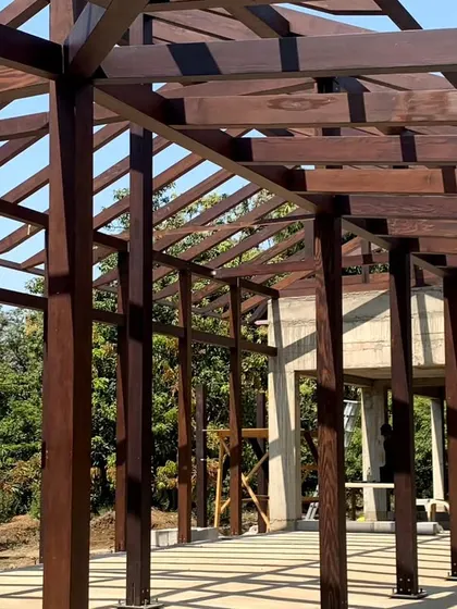The exposed timber frame of a house under construction in Awas, Alibaug. This structure, with its rhythmic columns and beams, is designed to be a modern interpretation of traditional post-and-beam construction.