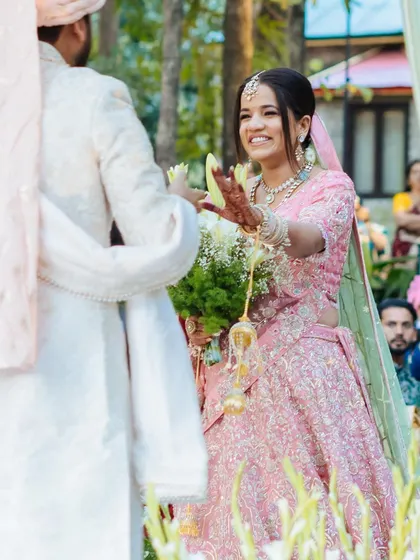 A happy, candid moment of the bride during her varmala ceremony, her smile lighting up the frame.