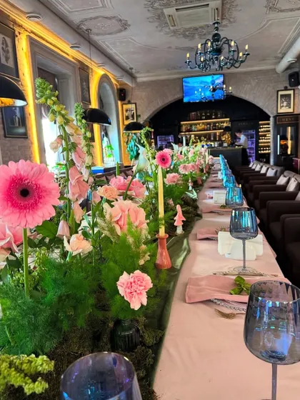 Another view of the long table setup, showing the full length of the floral runner and the elegant ambiance of the room.