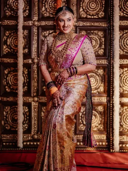 A full-length view of the bride's stunning wedding outfit. The custom blouse, with its detailed embroidery, is the centerpiece of her ensemble.